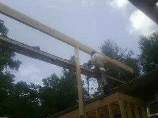 Carpenter setting a ridge beam over a new addition frame — Ice Dam Removal by Roofing Brothers in Windermere